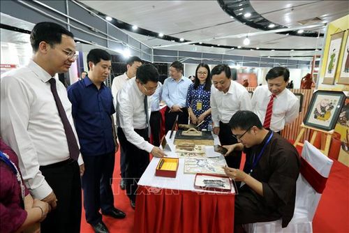 Các đại biểu tham quan nghệ nhân khắc bản in tranh Đông Hồ.
