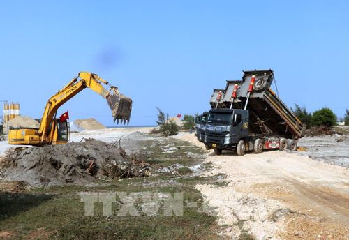 Nhà thầu khẩn trương huy động phương tiện, nhân lực thi công đoạn đầu tuyến nối cảng Mỹ Thủy thuộc dự án Quốc lộ 15D. Ảnh: Nguyên Linh – TTXVN