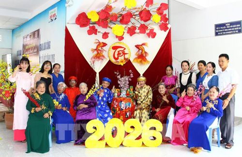 Nhân viên công tác xã hội tổ chức hoạt động tặng áo dài và chụp hình nhân dịp Tết nguyên đán cho người già neo đơn. Ảnh: Lê Thúy Hằng – TTXVN