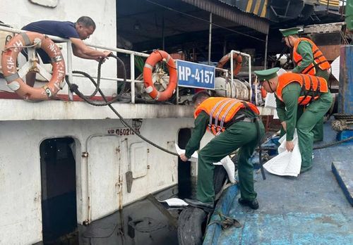 Cán bộ, chiến sĩ Ban Chỉ huy Biên phòng Cửa khẩu cảng Nghi Sơn thả vật liệu thấm dầu, khẩn trương xử lý sự cố tràn dầu sau vụ chìm tàu tại Cảng Quốc tế Long Sơn.