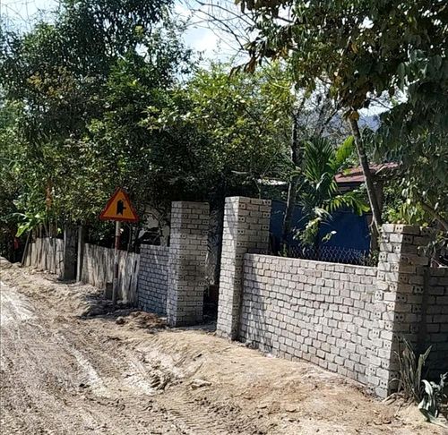 Hộ Bling Dước (xã Bến Giằng) xây tường rào cổng ngõ trong hành lang an toàn quốc lộ 14D. Ảnh: NGUYỄN SỸ