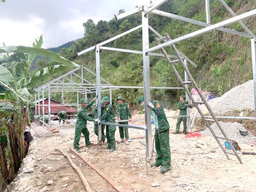 Cán bộ, chiến sĩ Đồn Biên phòng Pa Vệ Sử giúp nhân dân thi công nhà mới.