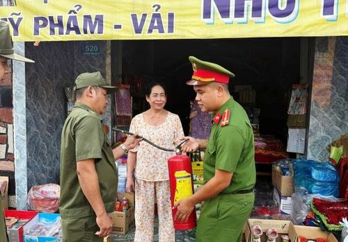 Cán bộ Công an xã Cần Giuộc tận tình hướng dẫn người dân sử dụng thiết bị chữa cháy.