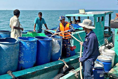 Người dân đảo Hòn Chuối sử dụng thùng phuy vận chuyển nước từ Tàu 527 lên đảo. Ảnh: Định Thắng