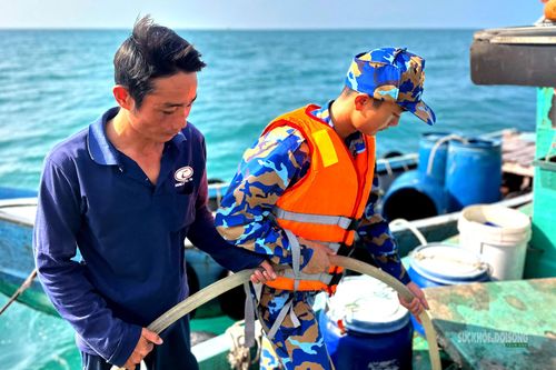 Ngư dân nuôi cá lồng bè tại đảo tranh thủ tiếp nhận nước từ bộ đội. Ảnh: Định Thắng