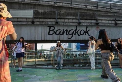  Khách du lịch chụp ảnh trên cầu vượt ở Bangkok vào tháng 3/2024. Ảnh: Reuters. 
