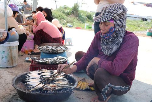 Tiểu thương thoăn thoắt trở cá trên bếp than hồng, hương thơm lan tỏa khắp bãi biển