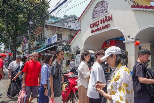  Khu vực trước cổng chợ Hàn đông đúc du khách, nhưng vỉa hè bị chiếm dụng khiến nhiều người phải di chuyển dưới lòng đường. Ảnh: XUÂN QUỲNH 