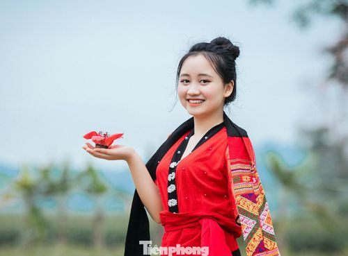  Thiếu nữ trong trang phục dân tộc truyền thống nâng niu bông hoa gạo trên tay. Ảnh: Rạng Đông 