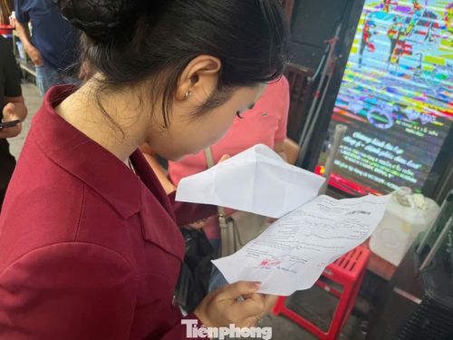 Nhân viên kiểm tra giấy hẹn trả vàng đúng ngày của khách.