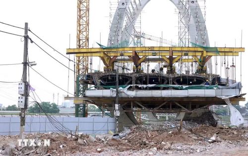 Quá trình thi công bị chậm tiến độ do giải phóng mặt bằng phía Gia Lâm chưa "sạch" do chưa di chuyển được trụ điện hạ thế. (Ảnh: Quốc Khánh/TTXVN)