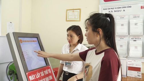 Cán bộ Trung tâm Phục vụ hành chính công xã Mậu A hướng dẫn người dân lấy số thứ tự, thực hiện thủ tục hành chính.