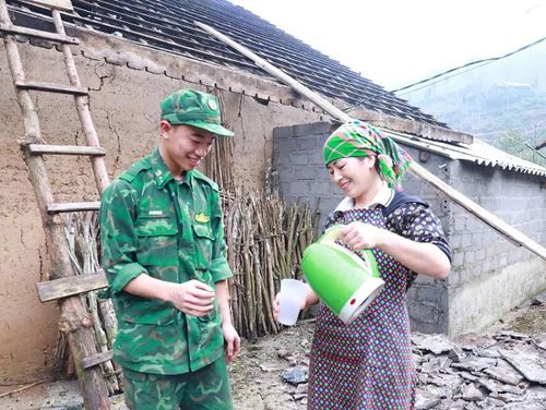 Chị Hầu Thị Mái mời nước các chiến sĩ trong thời gian giải lao và cảm ơn các chiến sĩ vì đã đến hỗ trợ gia đình lợp lại mái nhà.
