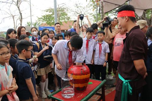 Học sinh thi nhau trổ tài trong màn bắt chạch trong chum.