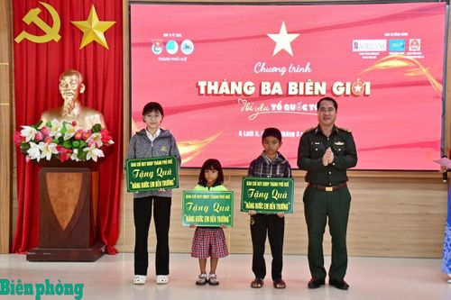Đại diện Ban Chỉ huy Bộ đội Biên phòng thành phố Huế tặng quà cho các em học sinh trong Chương trình “Nâng bước em đến trường” trong Chương trình “Tháng Ba biên giới”. Ảnh: Võ Tiến