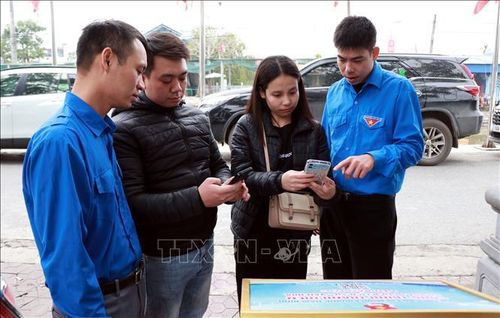 Đoàn viên thanh niên hướng dẫn du khách quét QR tìm hiểu thông tin về khu di tích đền Bảo Lộc, phường Nam Định (Ninh Bình). Ảnh: Nguyễn Lành/TTXVN