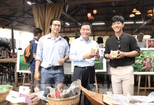 Các đại biểu tìm hiểu sản phẩm chế biến từ lúa mùa nổi. Ảnh: Hồng Nhung - TTXVN