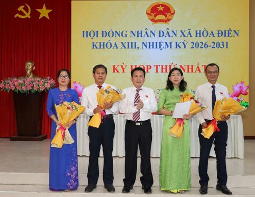 Bí thư Đảng ủy xã Hòa Điền Lê Thanh Hưởng tặng hoa chúc mừng các đại biểu được bầu giữ các chức danh thuộc HĐND xã.