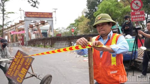Biển báo và rào chắn được đặt tại các lối lên cầu Long Biên nhằm ngăn phương tiện lưu thông trong thời gian thi công. (Ảnh: HỒNG QUÂN)