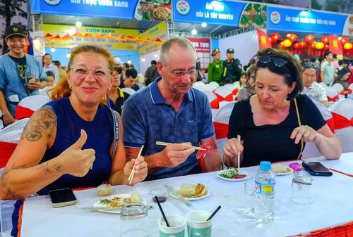  Ông Paul Leijdekkers (du khách đến từ Bỉ) cùng bạn rất thích thú thích thú khi được mời thưởng thức các món ăn. Ảnh: Đoan Ngọc 