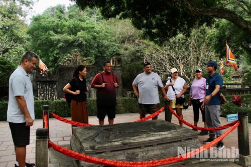 Du khách nước ngoài tìm hiểu về long sàng - một Bảo vật quốc gia tại đền thờ Vua Đinh Tiên Hoàng.