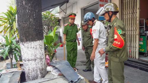  Lực lượng chức năng rà soát, phân loại các trường hợp được phép sử dụng và phải thu dọn trên vỉa hè. Ảnh: XUÂN QUỲNH 