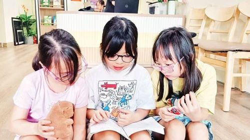 Các em nhỏ đọc sách để chuẩn bị cho cuộc thi trực tuyến. (Ảnh: MAI LỮ)