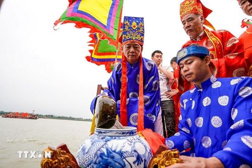 Thực hiện nghi lễ lấy nước từ sông Hồng. (Ảnh: Khánh Hòa/TTXVN)