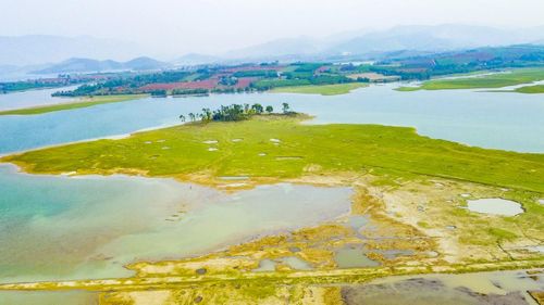 Xa xa là những cánh rừng xanh ngút ngàn, xen lẫn các thung lũng tự nhiên và triền đồi thoai thoải, hình thành nên các eo hồ, bán đảo hoang sơ. Tất cả hòa quyện, tạo nên một không gian khoáng đạt, đẹp như bức tranh thủy mặc, vừa hùng vĩ, vừa nên thơ.