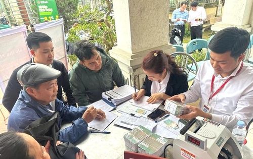 Người dân địa phương nhận tiền bồi thường. Ảnh: DH