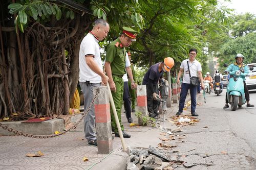 Lực lượng chức năng phường Láng triển khai phá dỡ bục bệ, vật cản... giành lại vỉa hè cho người đi bộ. Ảnh: Phạm Mạnh