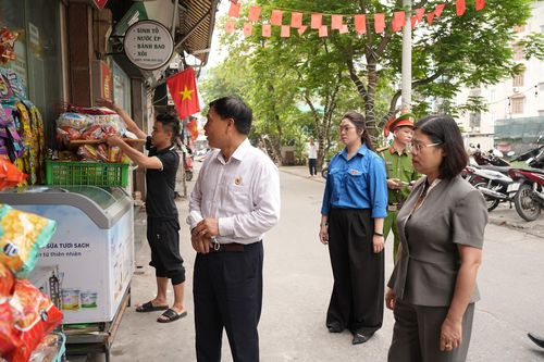 Lực lượng chức năng nhắc nhở, tuyên truyền và yêu cầu người dân không lấn chiếm khu vực đường đi. Ảnh: Phạm Mạnh