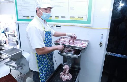 Nhân viên nuôi dưỡng trường mầm non tại Hà Nội xay thịt lợn đầu giờ sáng. Ảnh: Đình Tuệ