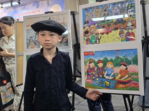 Em Sùng Quang Huy và tác phẩm "Năng lượng xanh trên cao nguyên đá quê hương em." (Ảnh: Minh Anh/Vietnam+)
