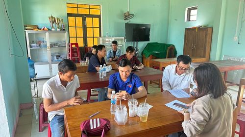 Cán bộ xã Tây Hồ hỗ trợ người dân tích hợp thông tin bảo hiểm y tế vào ứng dụng VNeID. Ảnh: HOÀNG ĐẠO