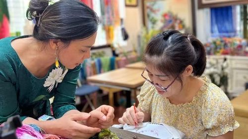 Nghệ nhân Nguyễn Thị Hằng (bên trái) trao đổi về kỹ thuật thêu.