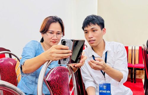 Chị Phạm Thị Bích Thủy, chuyên viên Trung tâm dịch vụ tổng hợp xã Nam Phù thao tác cùng kỹ thuật viên. Ảnh: Phương Xuyến