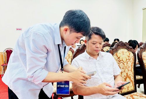 Anh Nguyễn Hoàng Long, cán bộ Ban quản lý dự án đầu tư - hạ tầng xã Nam Phù được hướng dẫn thực hiện một số kỹ năng nâng cao trên “HanoiWork”. Ảnh: Phương Xuyến