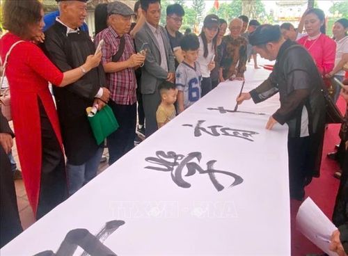 Trình diễn viết thư pháp. Ảnh: Mạnh Tú/TTXVN