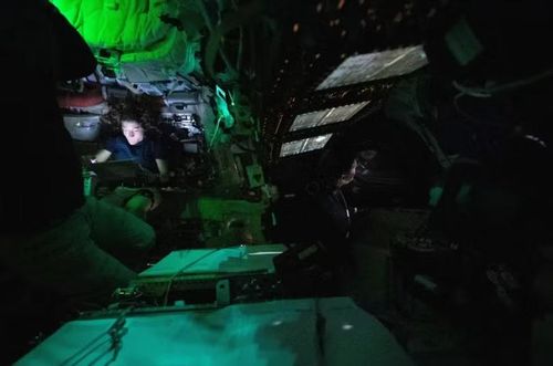 Hôm 3/4, nữ phi hành gia Christina Koch của NASA đọc sách trên máy tính bảng trong khoang tàu Orion, trong khi phi hành gia Jeremy Hansen (bên phải) nhìn ra ngoài qua một trong những cửa sổ của khoang Orion. Ảnh: NASA.