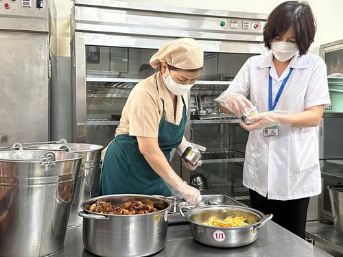 Nhân viên y tế cùng nhà bếp thực hiện lưu mẫu thức ăn hằng ngày tại bếp ăn bán trú trường tiểu học Núi Thành. Ảnh: H.T