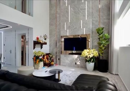 Phòng khách xây dựng theo lối thông tầng, tường được ốp đá sang trọng. Các cửa kính cũng được lắp để lấy ánh sáng từ thiên nhiên, tạo sự thông thoáng