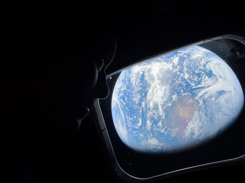 Reid Wiseman, chỉ huy sứ mệnh Artemis II, nhìn về Trái Đất qua cửa sổ của tàu vũ trụ Orion. (Ảnh: NASA)