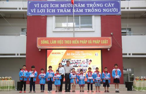 Các đồng chí lãnh đạo địa phương cùng BTC trao quà cho học sinh. Ảnh: VIỆT NGA