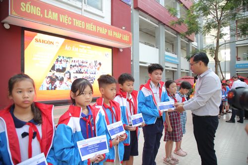 Bí thư Đảng ủy, Chủ tịch Hội đồng nhân dân xã Trương Minh Tước Nguyên trao quà cho các em học sinh. Ảnh: DŨNG PHƯƠNG