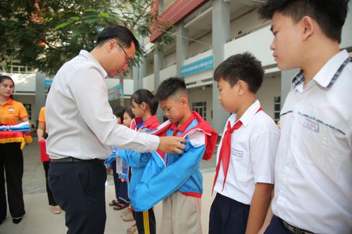 Các đồng chí lãnh đạo địa phương cùng BTC trao quà cho học sinh. Ảnh: VIỆT NGA