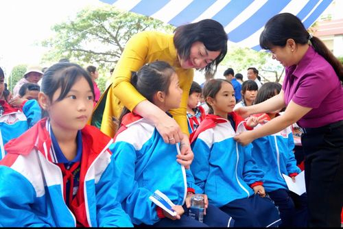 Đồng chí Bùi Thị Hồng Sương, Phó Tổng Biên tập Báo SGGP, Trưởng Ban tổ chức chương trình "Áo ấm đến trường" trao áo khoác cho các em học sinh. Ảnh: VIỆT NGA