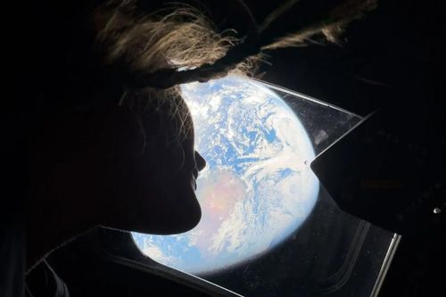 Phi hành gia Christina Koch nhìn Trái Đất qua cửa sổ trên tàu vũ trụ Orion. Ảnh: NASA