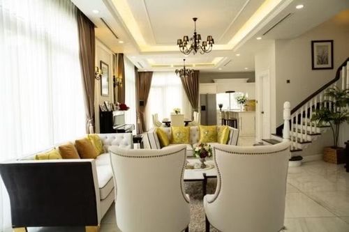 . Ở tầng 1, không gian phòng khách và bàn ăn thông với nhau, khá thoáng đãng. Những chi tiết như đèn chùm màu đen, hay gối vuông trên ghế sofa màu vàng khiến không gian có điểm nhấn nhưng vẫn tinh tế
