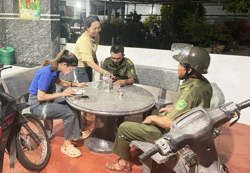 Lực lượng an ninh cơ sở ở xã Duy Nghĩa hướng dẫn kích hoạt VNeID mức 2 và tích hợp sổ sức khỏe điện tử vào VNeID cho người dân. Ảnh: PHAN VINH